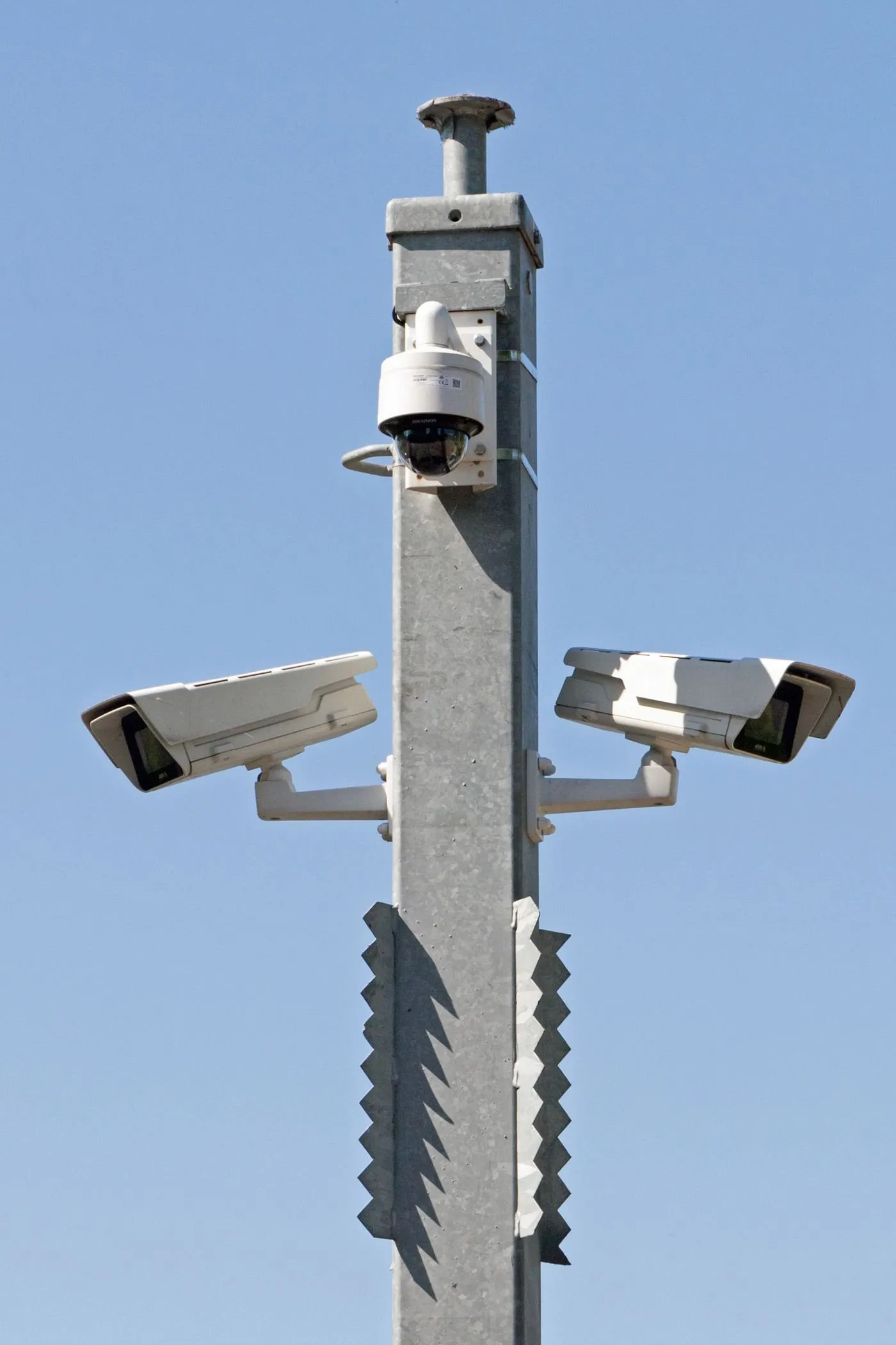 CCTV cameras mounted on a pole against a blue sky