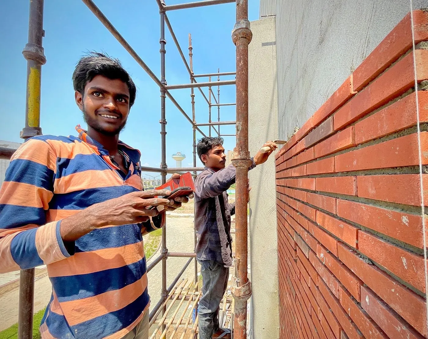 Workers at a brick construction site with scaffolding